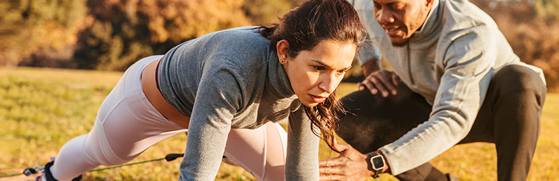 Female and male entrepreneur in exercise clothes working on specific workouts for their online fitness business.