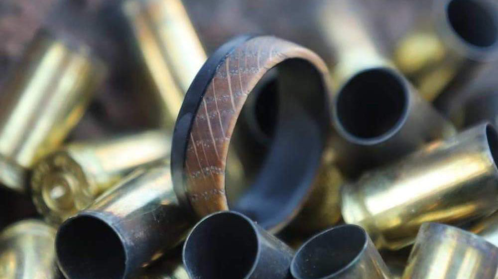 wooden carbon fiber ring on a bunch of cartridges | feature | Benefits Of Getting A Carbon Fiber Wedding Band