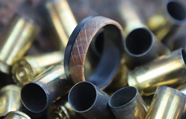 wooden carbon fiber ring on a bunch of cartridges | Benefits Of Getting A Carbon Fiber Wedding Band